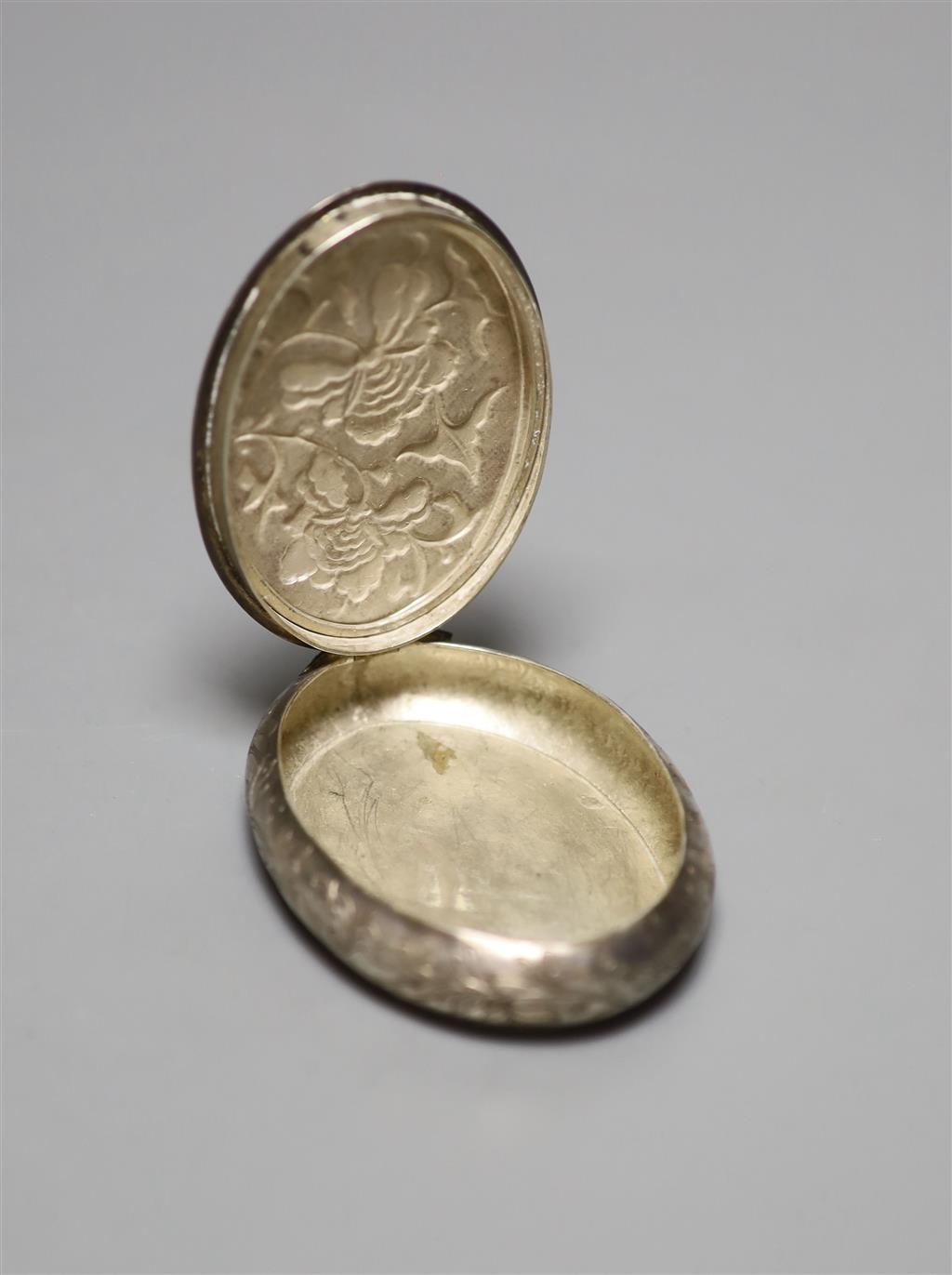 A late 19th/early 20th century Chinese white metal oval snuff box, decorate with foliage, 73mm.